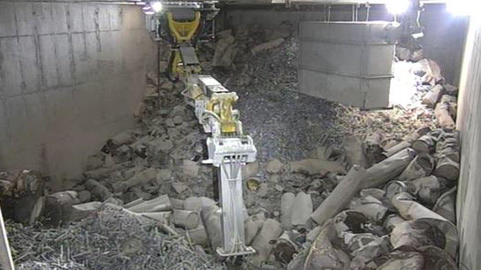 Nuclear waste being extracted by mechanical arm