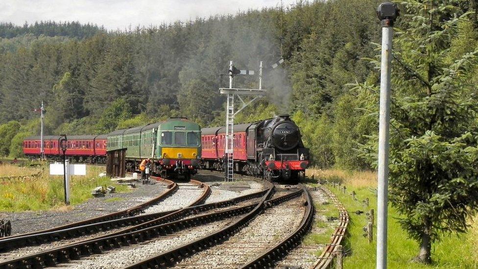 A steam train passing a diesel train