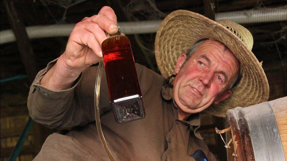 Peter Bignall siphons a bottle of whisky direct from the barrel at Belgrove Distillery