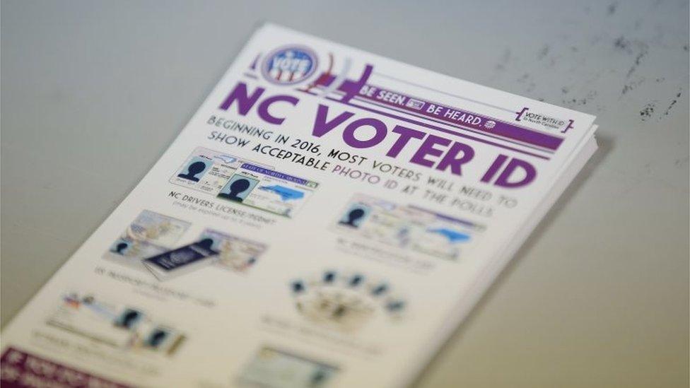 ]A pile of government pamphlets explaining North Carolina's controversial "Voter ID" law sits on table at a polling station in Charlotte, North Carolina