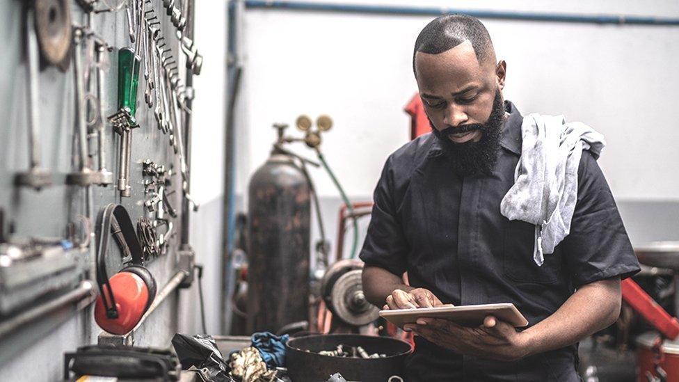 Mechanic on tablet in workshop