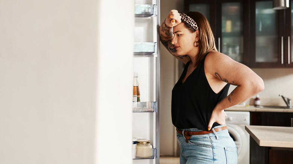 woman looking in fridge