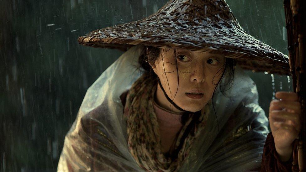 Li, the peasant protagonist of I Am Not Madame Bovary, is pictured in the rain wearing a conical hat