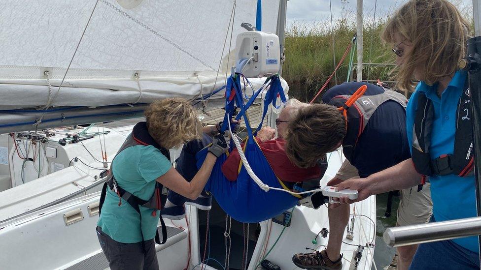 Alan Davies being hoisted into a boat