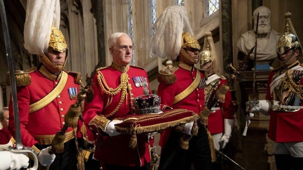 The Imperial State Crown is carried through the Norman Porch