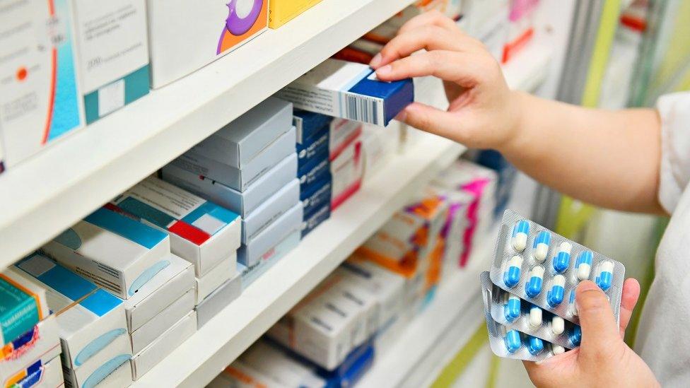 Medicine cabinet hand holding pills