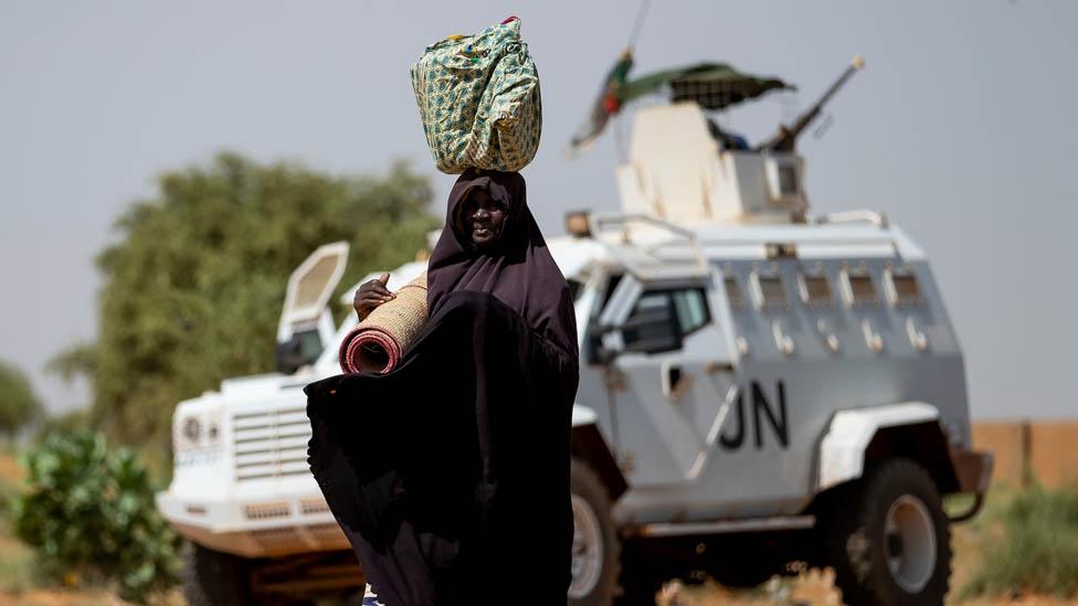 A woman in Mali near a UN vehicle