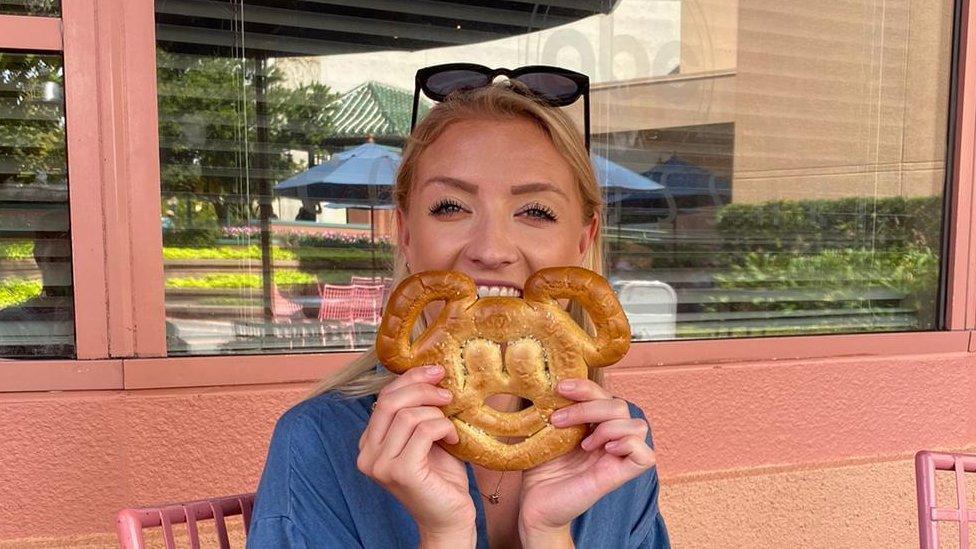 Hayley holding a mickey mouse pastry