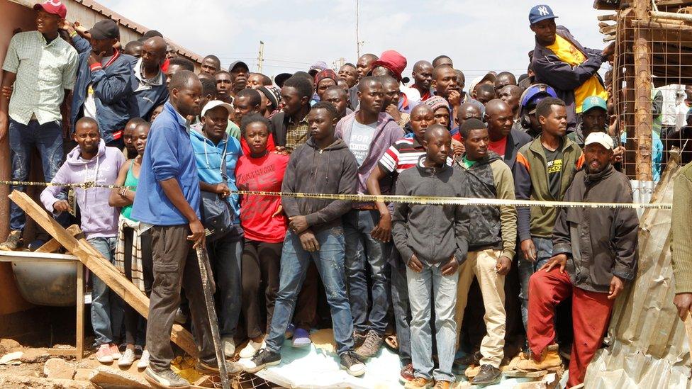 Kenyans watch as rescue teams and police officers search the debris