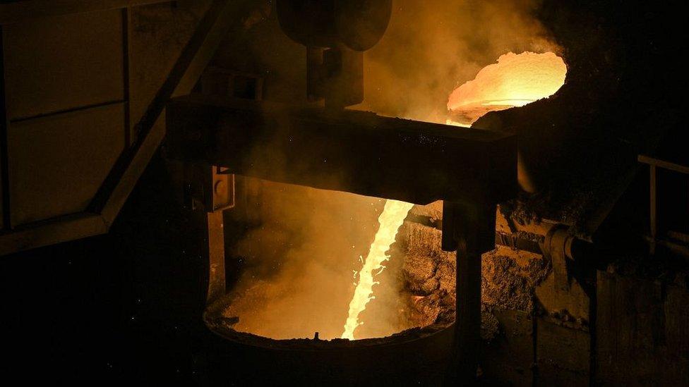 Molten metal is deposited into a container during a government organised tour at a Tiangong International plant, makers of high quality steel and tools, in Zhenjiang in China's eastern Jiangsu province on October 12, 2020.