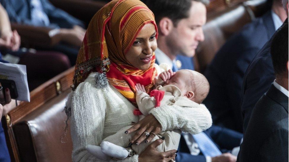 Democratic Representative Ilhan Omar holds the child of Democratic Representative Eric Swalwell while waiting for Democratic House Leader Nancy Pelosi to accept the gavel to once again become Speaker of the House in the US Capitol in Washington