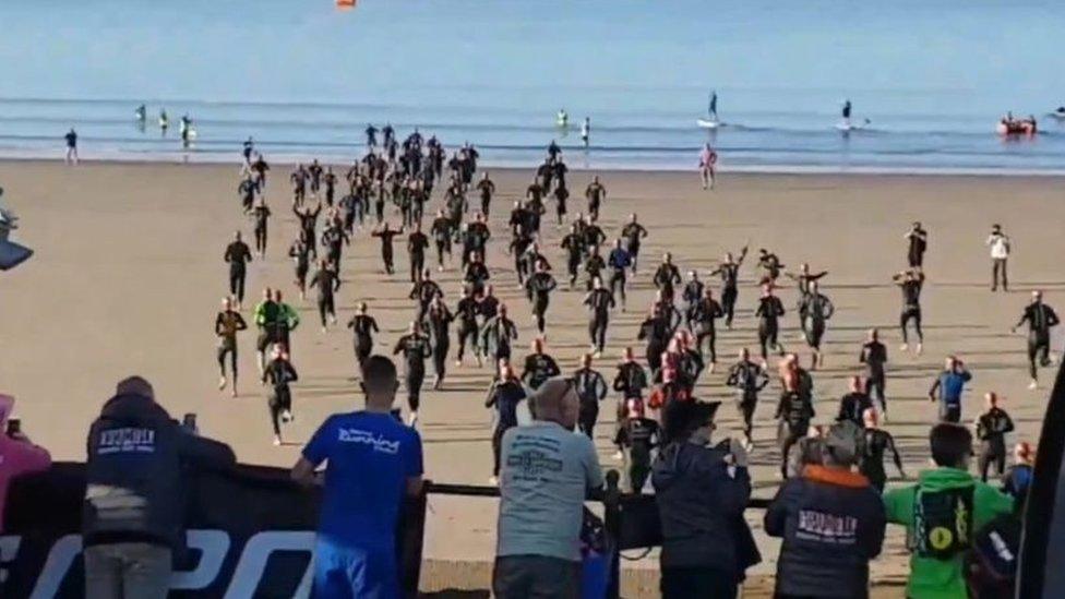 Triathlon runners on beach