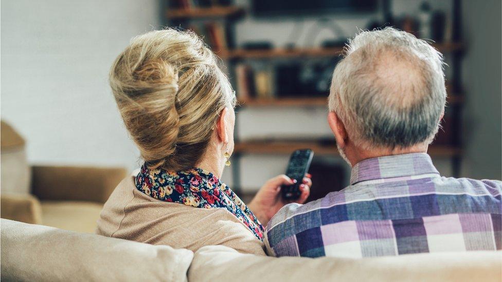 Couple sitting watching television stock image