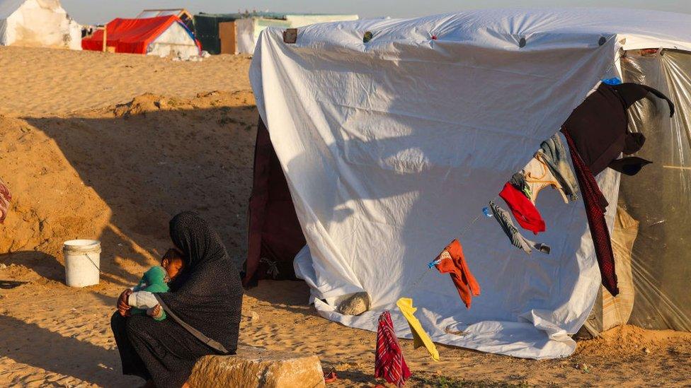 woman with baby by tent