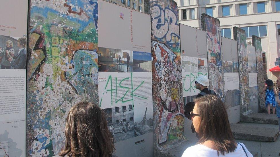 Tourists in Berlin visit one of the sites of the remains of the Berlin Wall