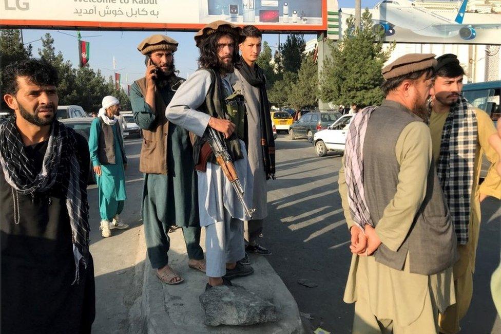 Taliban fighters stand outside Hamid Karzai International Airport in Kabul, Afghanistan, August 16, 2021.