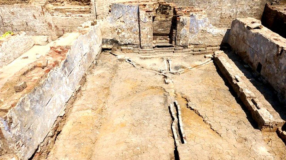 Image showing an excavated room with royal blue walls and a brick fireplace