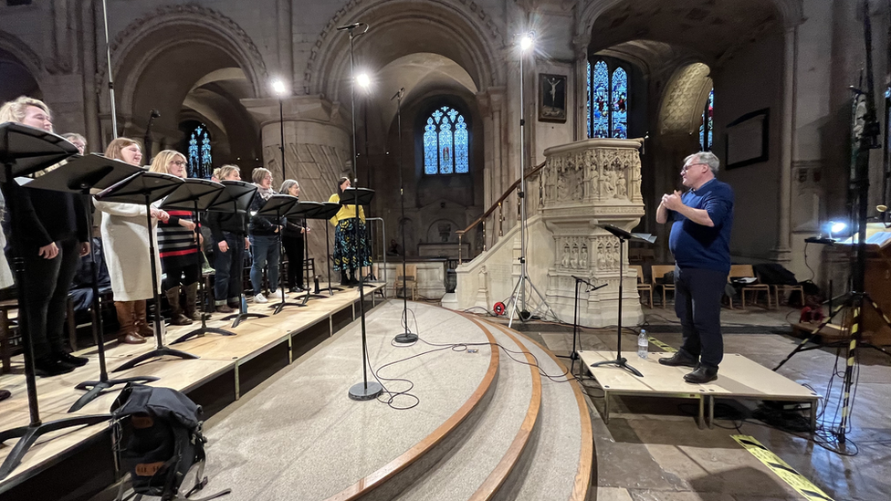 Ed Balls conducting in front of BBC Singers chamber choir at Norwich Cathedral