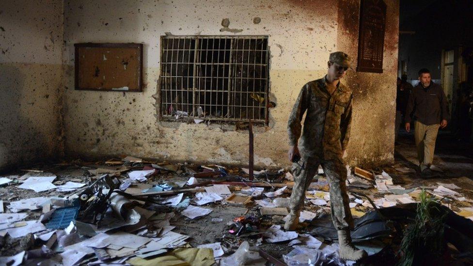 A Pakistani soldier walks amid the debris