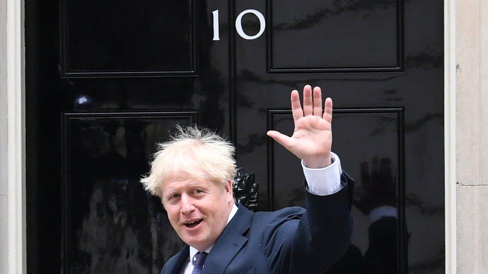 Boris Johnson waves as he enters No 10