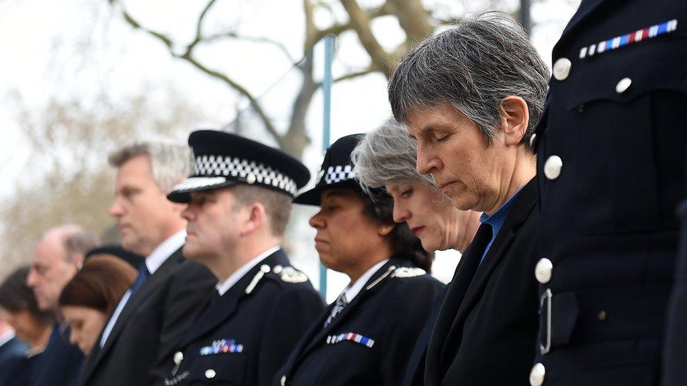 London Metropolitan Police Commissioner Cressida Dick (R) bows her head during a one minutes silence for their fallen officer, PC Keith Palmer, outside New Scotland Yard