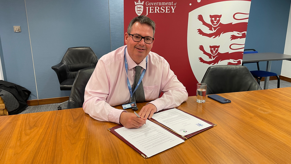 Man signing paper on table