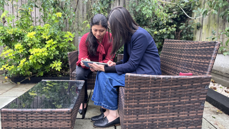 Sara (r) with cousin Dr Sancy Low looking at pictures of Mr Teoh