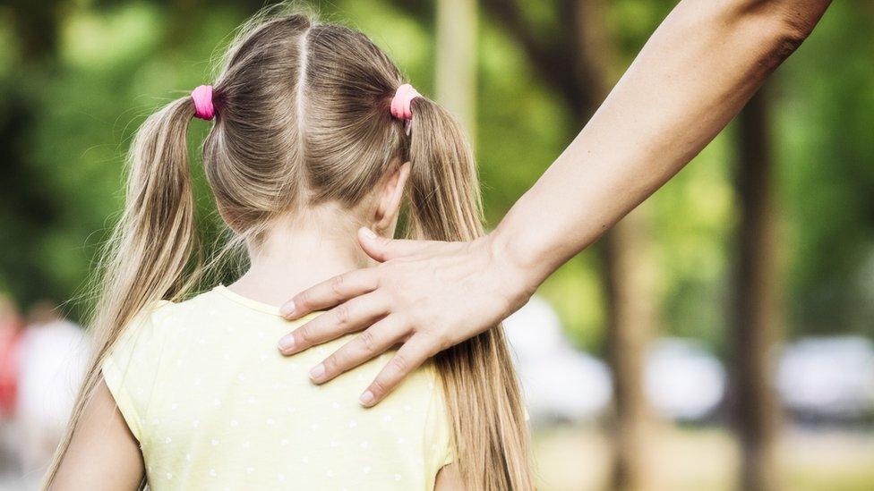 Adult's hand on child's shoulder