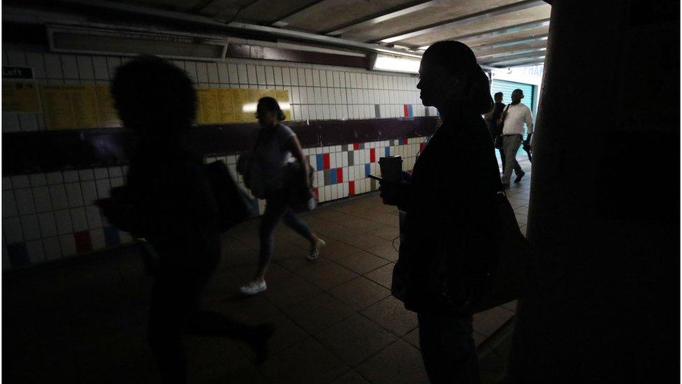 People walking in complete darkness at Clapham Junction station in London