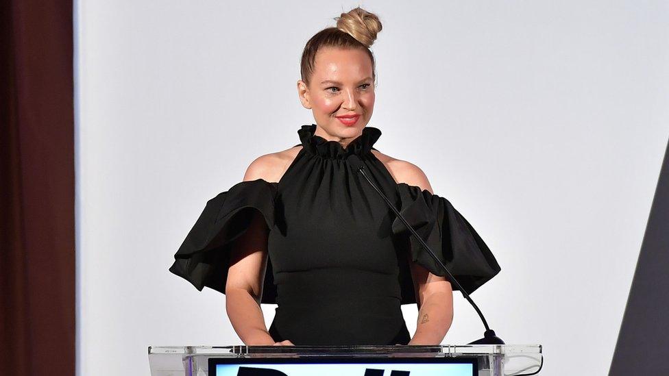 Sia, speaking at a podium on a stage