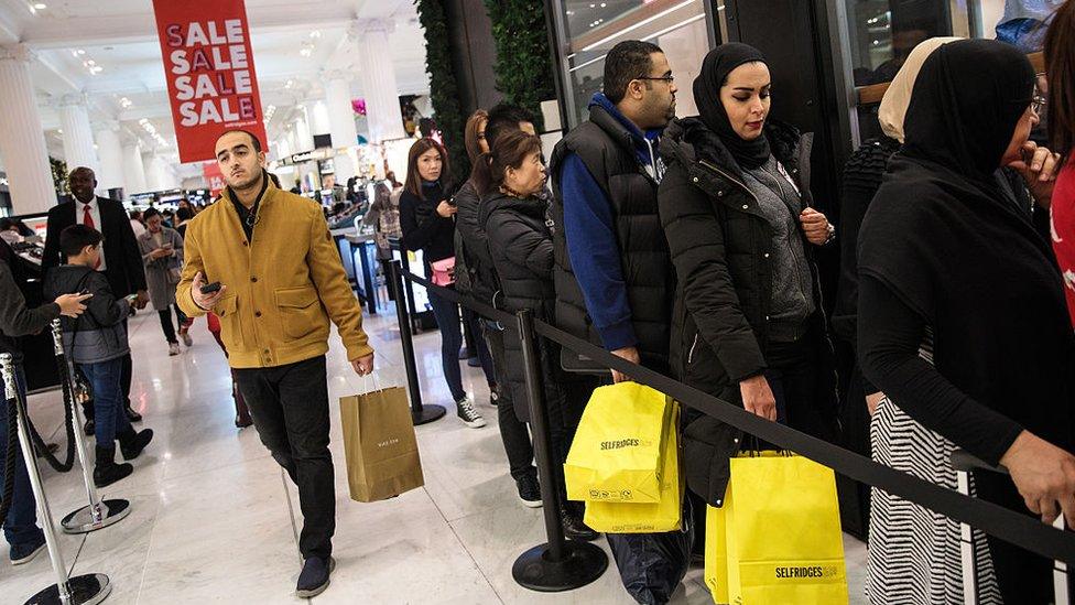 Customers queue outside a designer stall during the Boxing Day sale at Selfridges