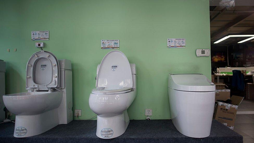 Models of the 'Auto-cover Changing toilets' are on display in a showroom of Trump Toilet products in Shanghai on November 18, 2016