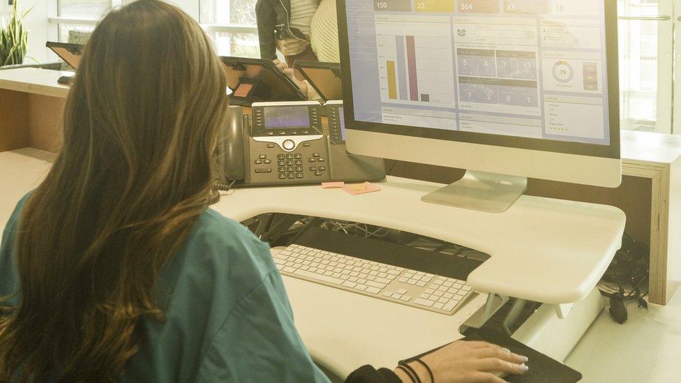 A receptionist at work at a computer screen