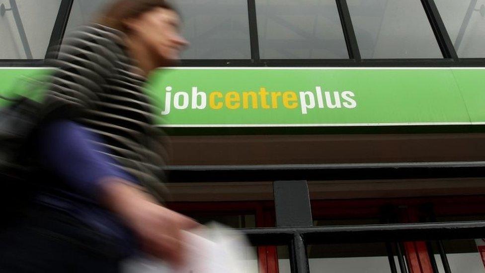 A woman walking past job centre plus