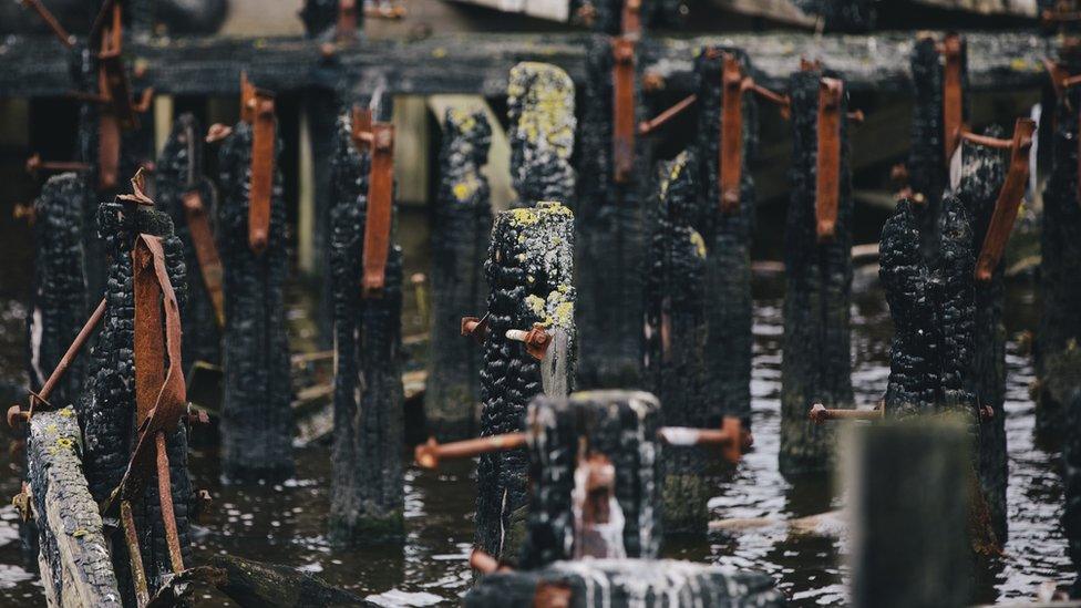 Charred remnants of timber panels following an arson attack