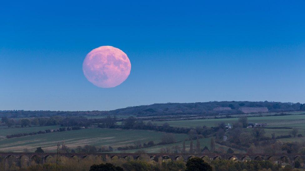 A reddish moons rises over the Harringworth Viaduct