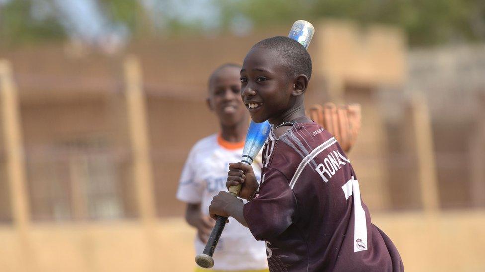 Young Senegalese children playing baseball,