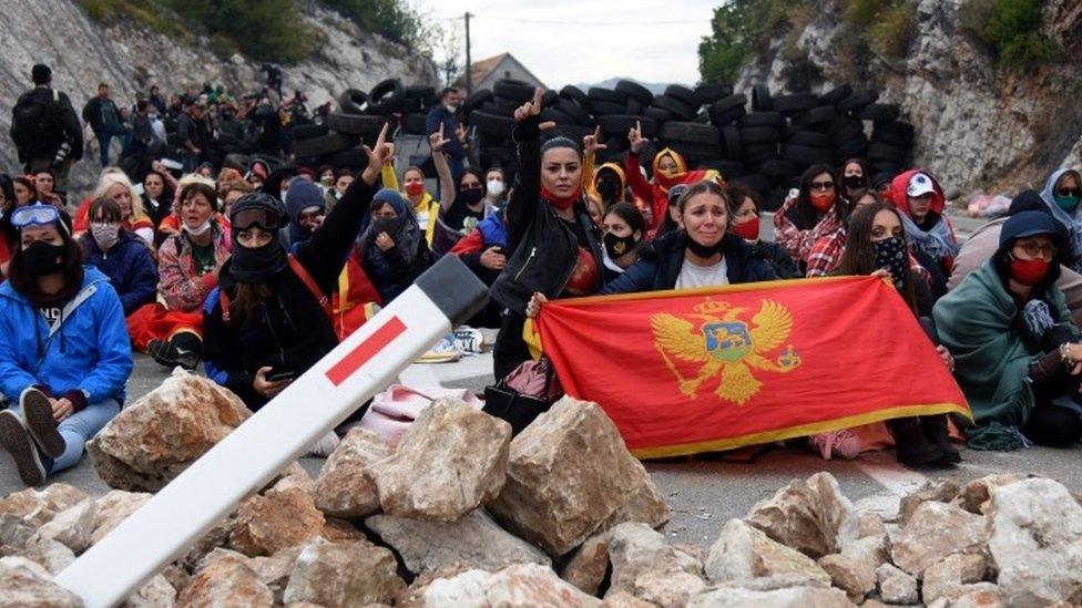 Protesters hold flags at a road block in Montenegro