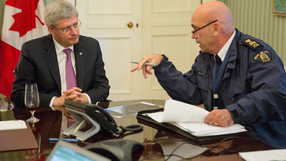 This photo provided by the Prime Minister"s office shows the head of RCMP Bob Paulson briefs Canadian prime Minister Stephen Harper on the shootings at Parliament Hill in Ottawa on Wednesday Oct. 22, 2014