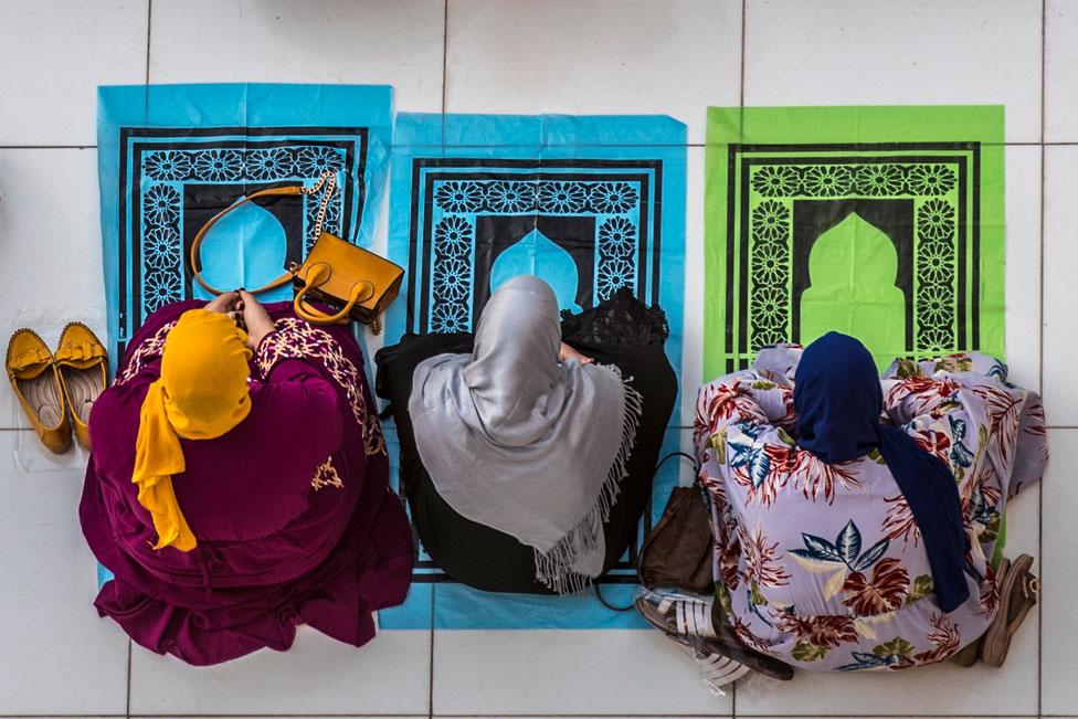 An aerial view of three Muslim worshippers attending Eid al-Fitr prayer at al-Azhar mosque in the Egyptian capital Cairo