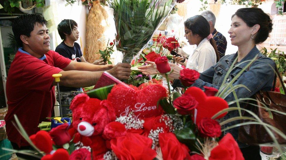 Customers buy flowers and valentine's gifts at a florist in Dubai on 13 February, 2008.