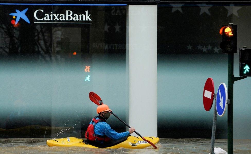 A man rides a kayak on a flooded road, following heavy rainfall in Pamplona, Spain, December 10, 2021