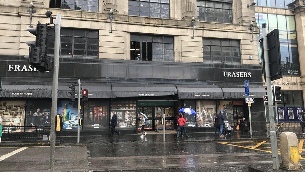 People walking past an empty store in Edinburgh