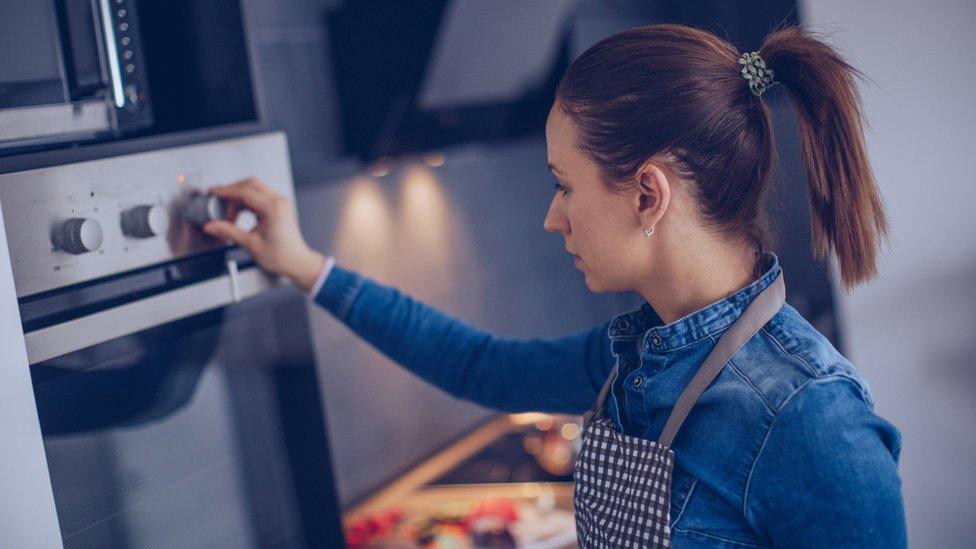 Woman cooking in oven