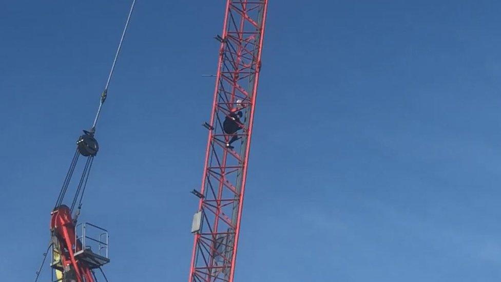 A protester scaled a crane in Norwich