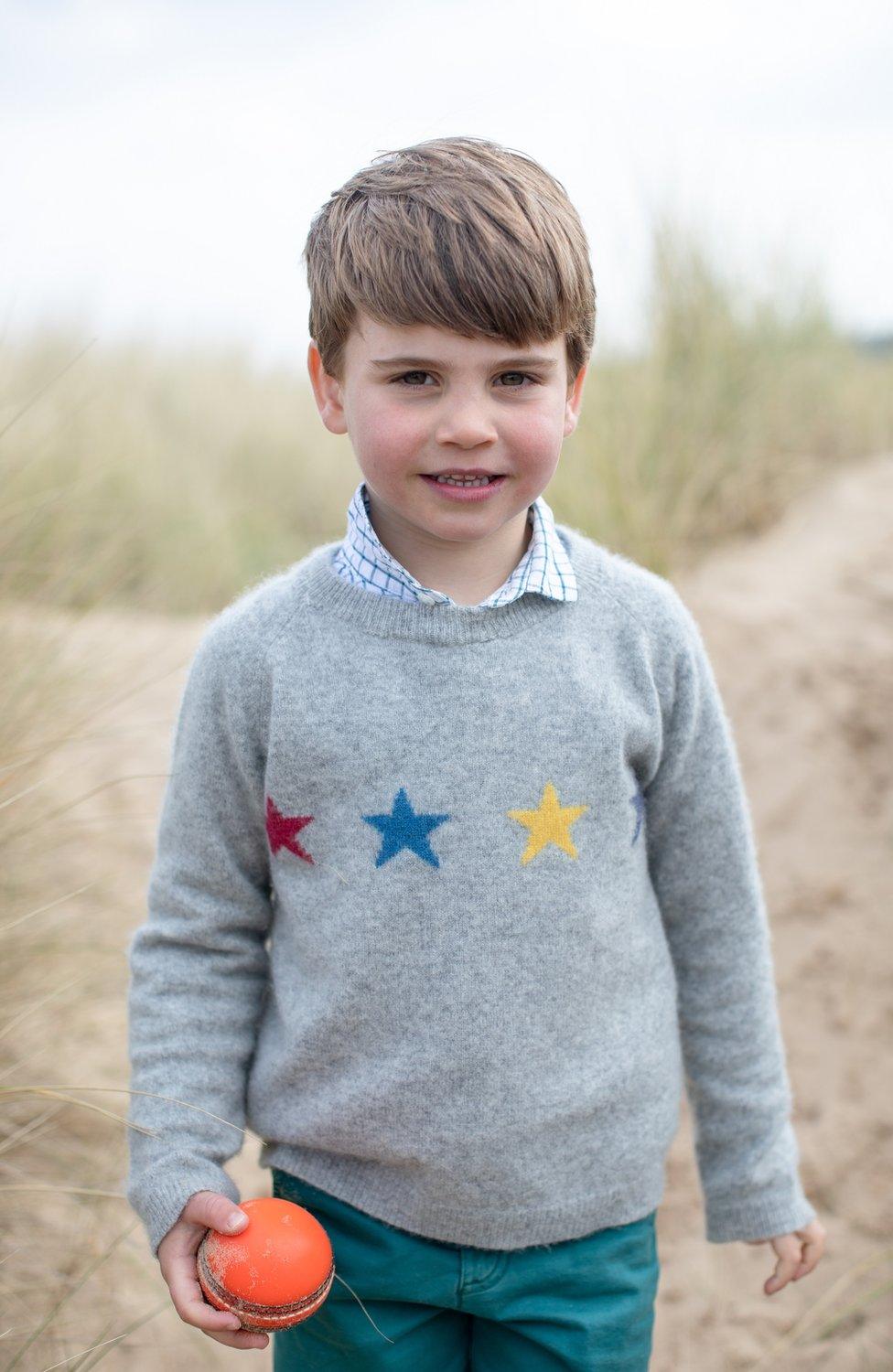 Prince Louis holding a cricket ball