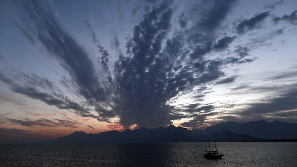 Tourists travel by ship during a sunset near Antalya city centre, 16 November 2015