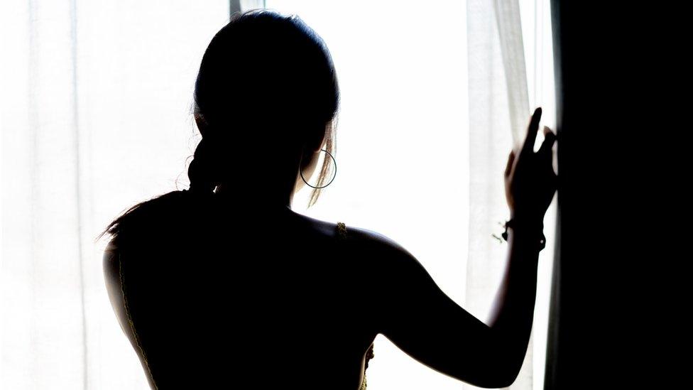 Woman looking out of window, stock image