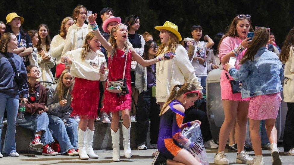 Swift fans, also known as "Swifties" with no tickets sing and dance during the concert outside the Melbourne Cricket Ground.