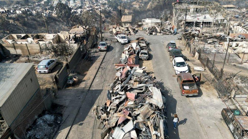 Remains of houses burned are seen following the spread of wildfires in Vina del Mar, Chile